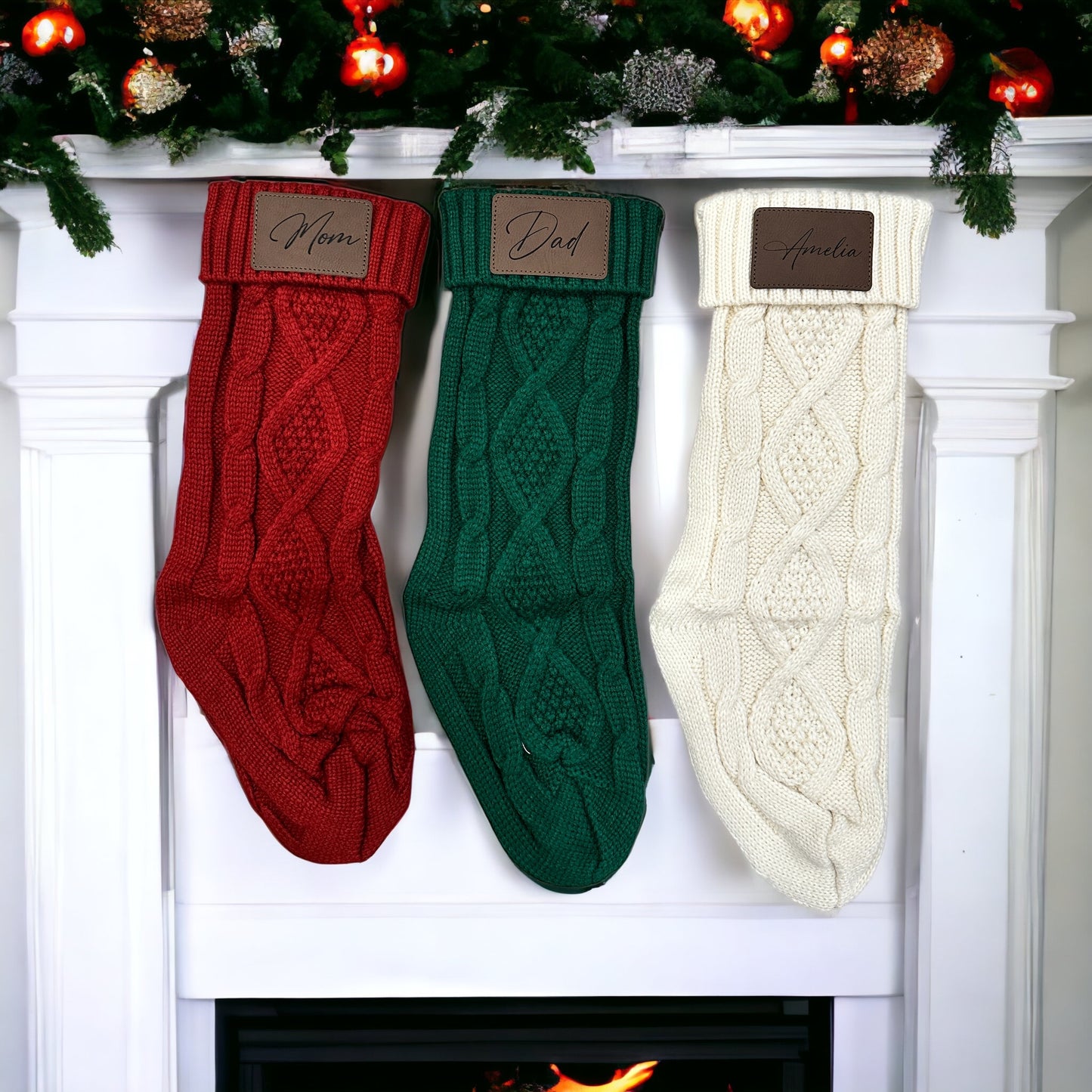 Three Christmas stockings labeled 'Ethan', 'Dad', and 'Mom' hanging on a fireplace mantle with decorative items.