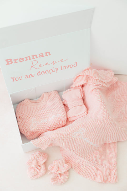 Pink baby outfit with matching headband and socks in a box, personalized with 'Brennan Reese'.