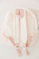 Pink baby carrier with quilted backrest on a light background